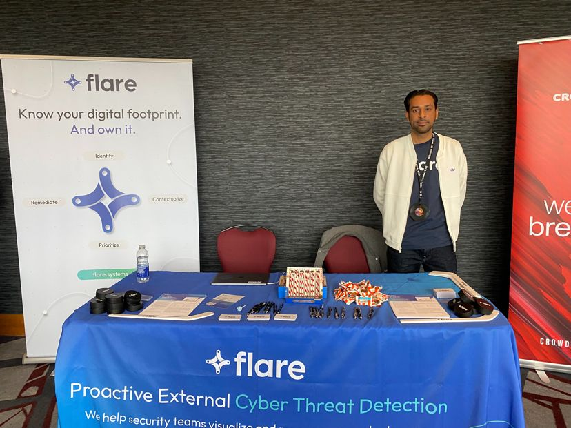 Flare Channel Account Executive Nabeel Sheikh stands behind a table with Flare flyers and candy next to the Flare banner.